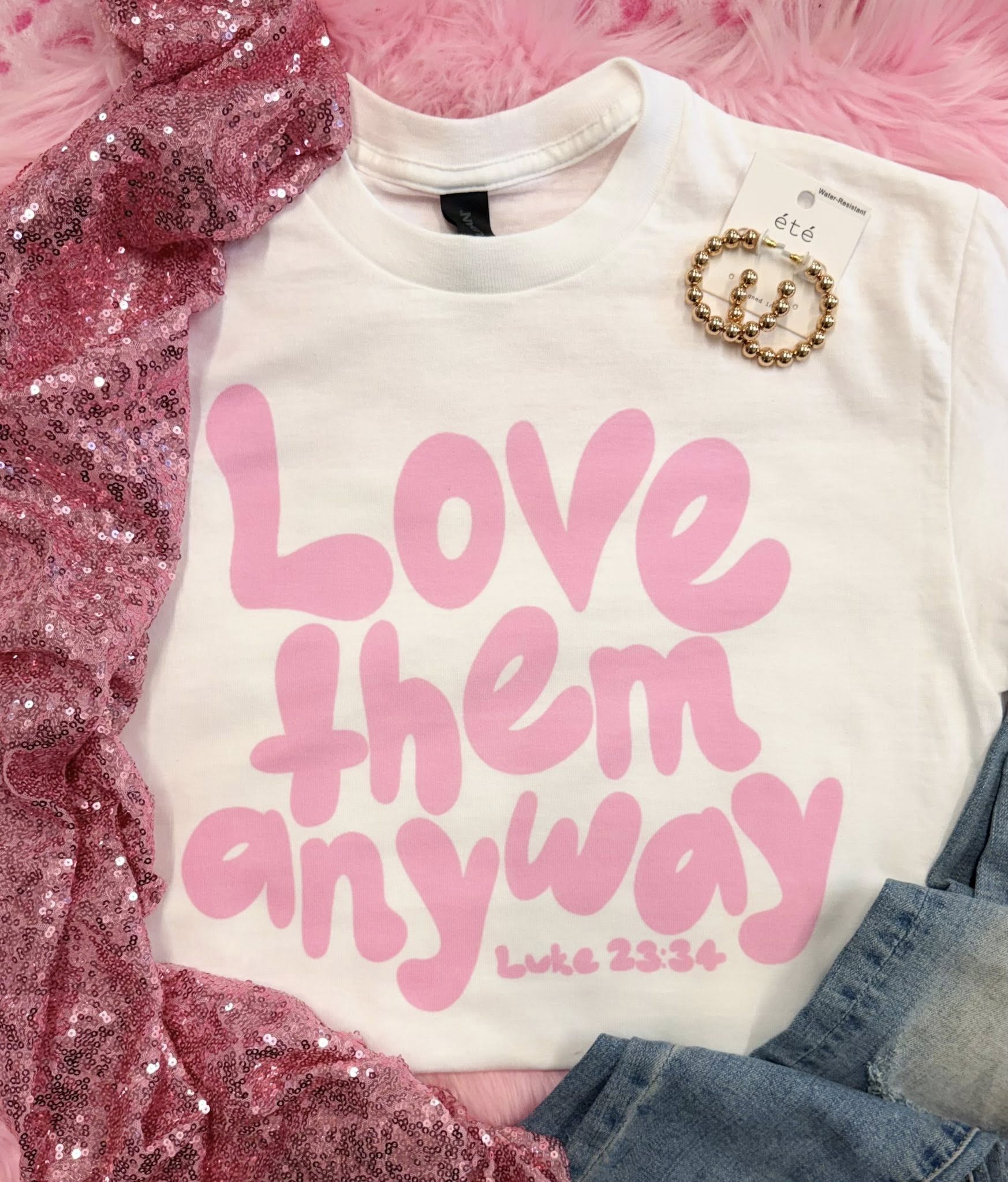 Luke 23:34 Love them anyway pink sublimated on white dry-blend Gildan tee