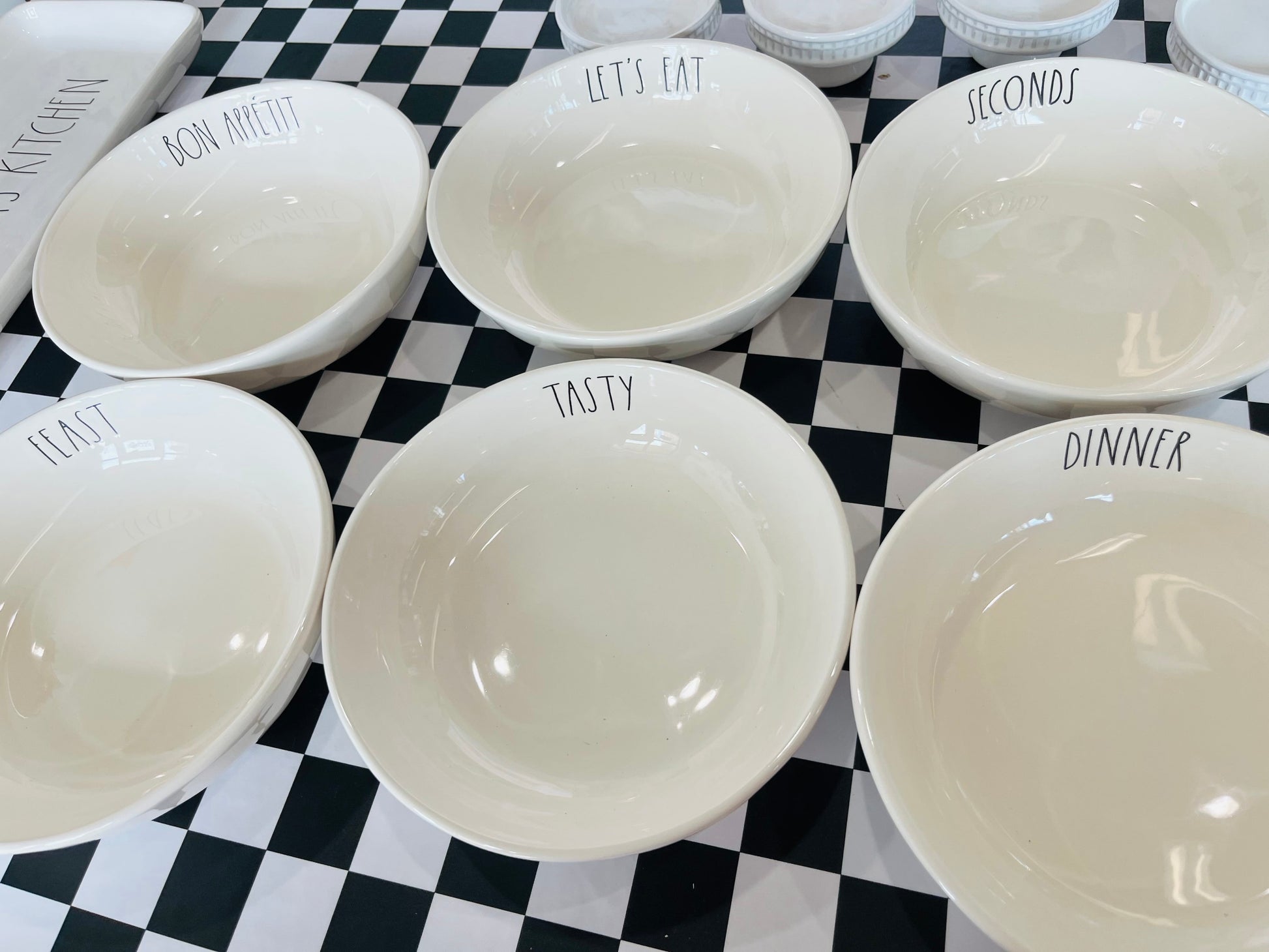 Set of white bowls with text on a black and white checkered background